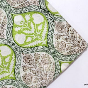 May include: Green and brown floral fabric with a white background. The fabric has a repeating pattern of stylised flowers and leaves.