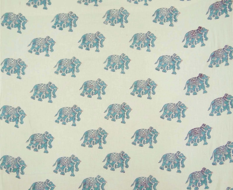 May include: A white fabric with a repeating pattern of blue elephants. The elephants are facing right and have a detailed design.