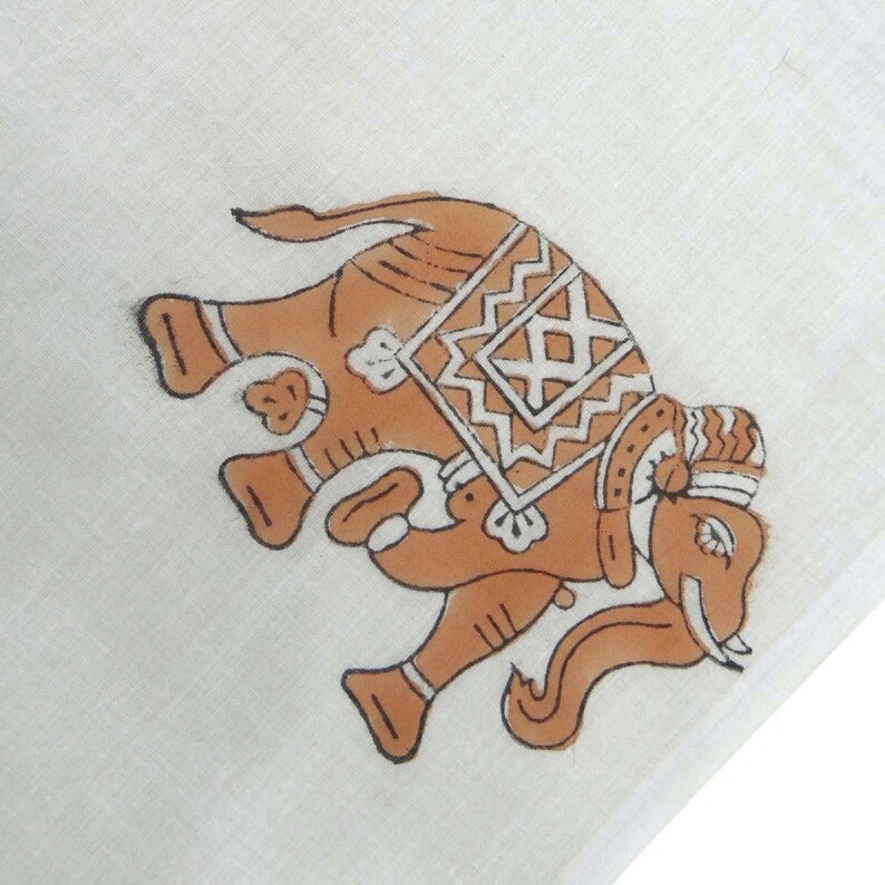 May include: A hand-painted brown elephant with white details on a white fabric background. The elephant is decorated with a geometric pattern on its back.