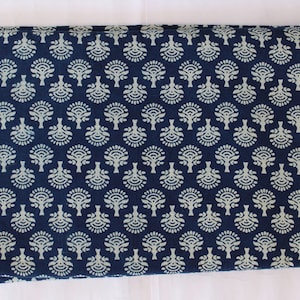 May include: Indigo blue cotton fabric with a white floral pattern. The fabric is folded in half and has a small tag on the top left corner.