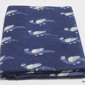 K&ouml;nnte beinhalten: Ein gefaltetes St&uuml;ck indigo-blauer Baumwollstoff mit einem wei&szlig;en Vogelmuster. Der Stoff ist ein traditionelles indisches Handblockdruckdesign.