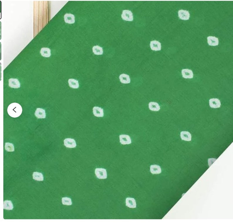 May include: Green fabric with a white polka dot pattern. The fabric has a subtle sheen and a soft texture.