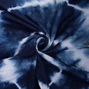 May include: Blue and white tie-dye fabric with a swirling pattern. The fabric is soft and has a slightly textured surface.