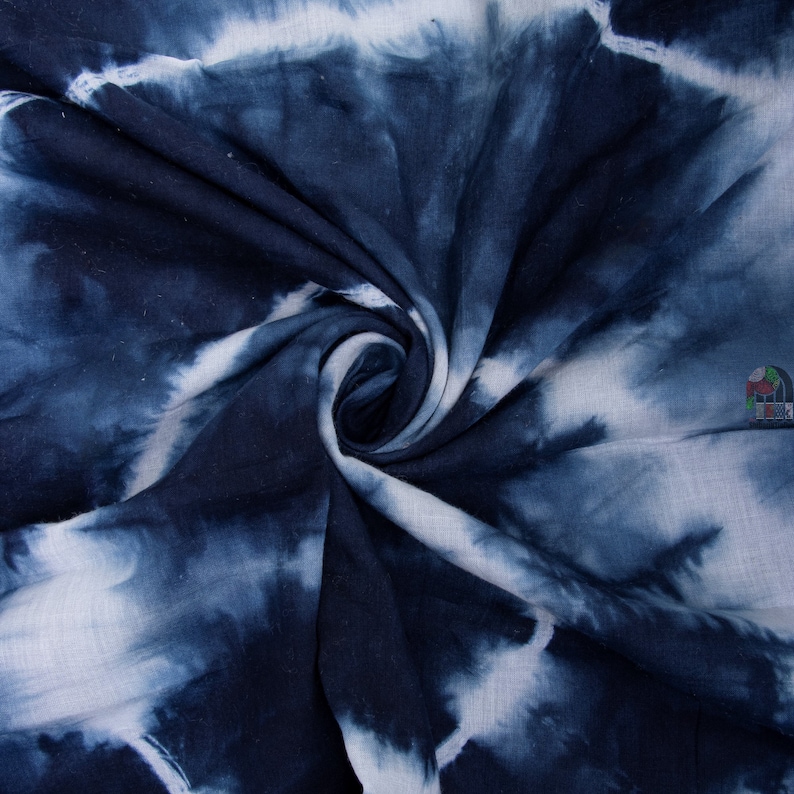 May include: Blue and white tie-dye fabric with a swirling pattern. The fabric is soft and has a slightly textured surface.