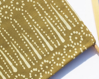 May include: A close-up of a green fabric with a white pattern of dots and lines. The fabric has a textured surface.