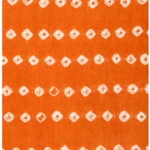 May include: Orange fabric with a white tie-dye pattern of small squares. The fabric has a subtle texture.