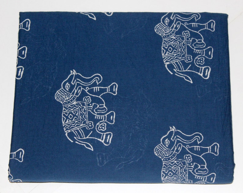 May include: A blue cotton fabric with a white elephant pattern. The elephants are decorated with geometric designs.