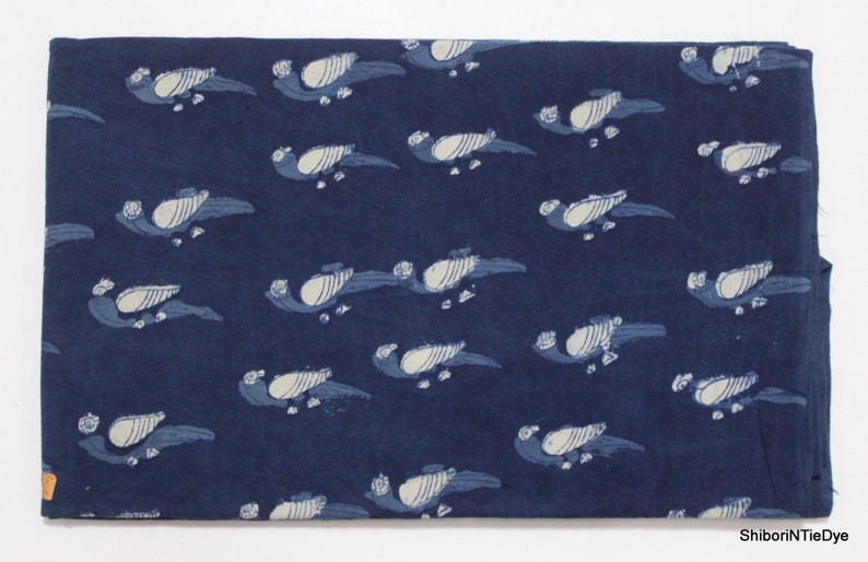 K&ouml;nnte beinhalten: Indigo blauer Baumwollstoff mit einem wei&szlig;en Vogelmuster. Der Stoff ist ein traditioneller indischer Handblockdruckstoff.