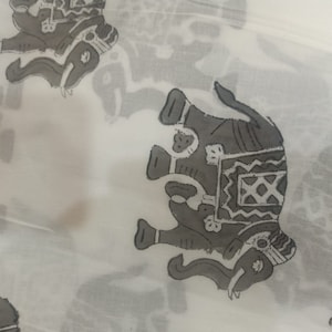 May include: White fabric with a repeating pattern of gray elephants. The elephants are stylized and have intricate designs on their backs.