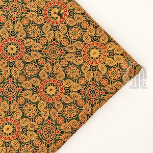 May include: Green fabric with a repeating pattern of red, gold, and black paisley and floral designs.