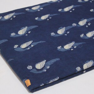 K&ouml;nnte beinhalten: Indigo blauer Baumwollstoff mit einem wei&szlig;en Blumenmuster. Der Stoff ist in der H&auml;lfte gefaltet und hat ein kleines Etikett mit dem Text "ShiboriNTieDye".
