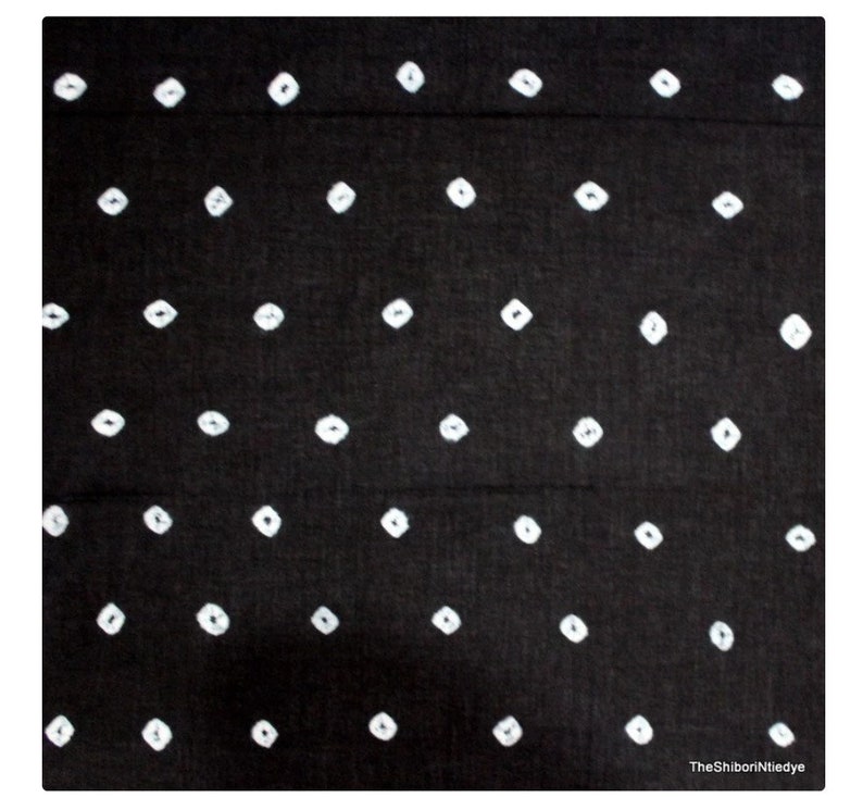 May include: Black fabric with a white shibori tie-dye pattern of small diamond shapes.