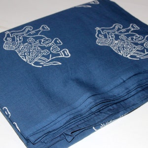 May include: A folded stack of blue fabric with a white elephant print. The fabric is folded neatly and has a smooth texture.