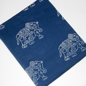 May include: A blue cotton fabric with a white elephant print. The elephants are in a traditional Indian style with intricate details. The fabric is perfect for crafting projects, quilting, or making clothing.