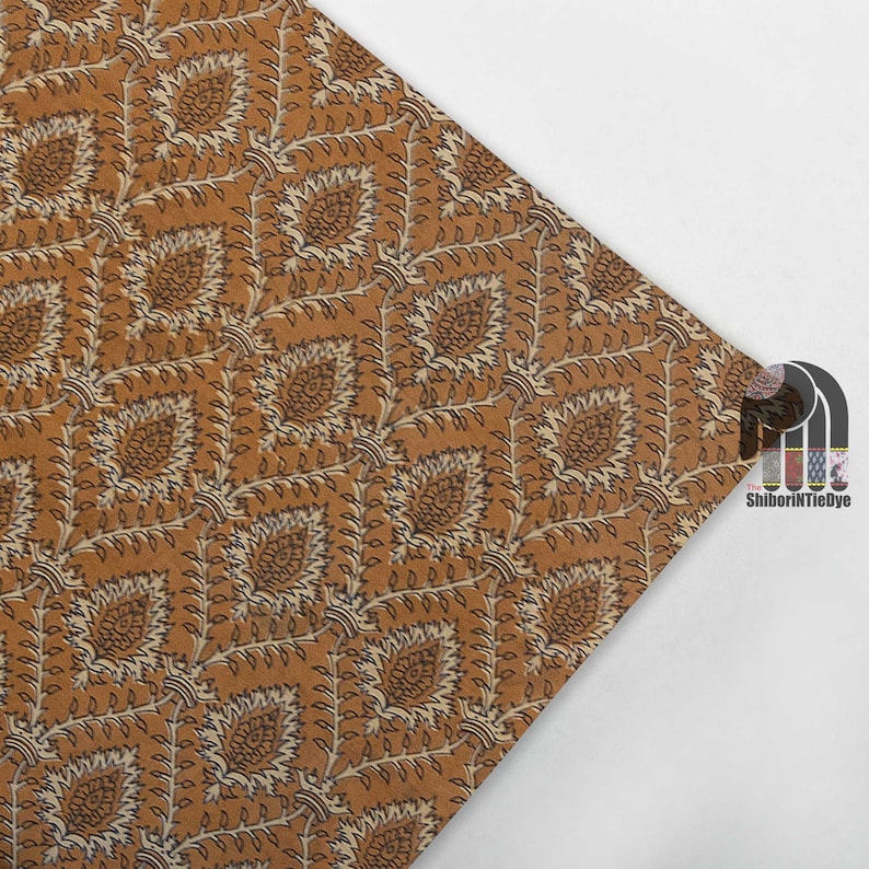May include: A brown fabric with a white and brown floral pattern. The fabric has a subtle sheen and a soft texture.