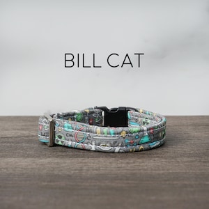 Könnte beinhalten: Ein graues Katzenhalsband mit einer schwarzen Schnalle und einem wissenschaftlichen Aufdruck mit bunten Illustrationen von Bechern, Reagenzgläsern, DNA-Strängen und anderen wissenschaftlichen Symbolen.