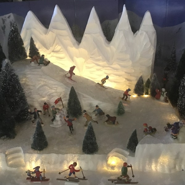 Plataforma de exhibición de pueblo navideño con pista de esquí, colina para trineos y montaña, iluminada para el departamento 56 de Lemax. Aldeanos navideños del Polo Norte de Dickens.
