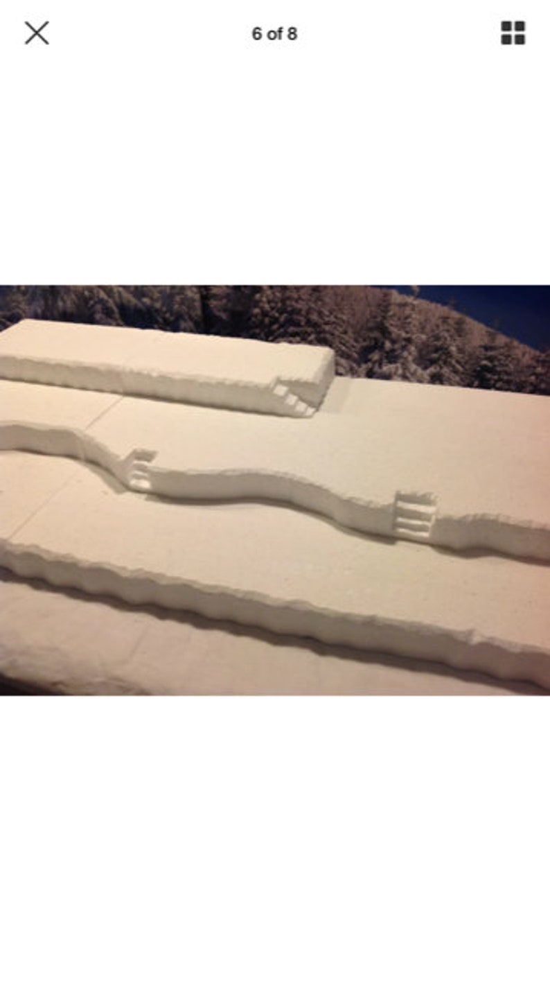 May include: A white foam terrain model with three levels and three sets of stairs. The model is designed for tabletop gaming.
