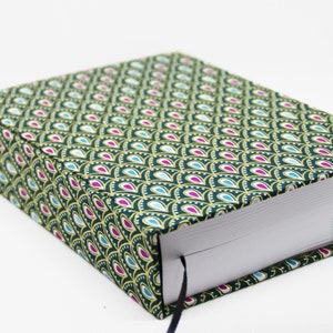 Op de afbeelding: Een groen hardcover notitieboek met een gouden en turquoise patroon. Het notitieboek heeft een lint-bladwijzer.