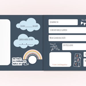 May include: A dark blue memory book spread with white text and illustrations. The left page features a large blank frame, cloud shapes, and a rainbow. The right page includes fields for personal details, a rocket, and alphabet blocks.