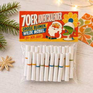 Può includere: Un sacchetto di plastica trasparente contenente ventiquattro rotoli di carta bianca fissati con piccoli elastici colorati. L'intestazione presenta un'illustrazione di Babbo Natale, un fiore giallo e il testo 70ER ADVENTSKALENDER GROBE BLUMEN. WILDE MOBEL. 24x ACH JAAA!