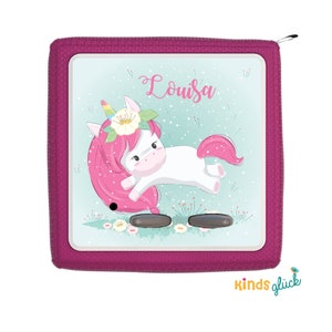 May include: A pink zippered pouch with a white unicorn wearing a flower crown and the name "Louisa" printed on it. The pouch has a blue and green background with white flowers and a light blue sky.