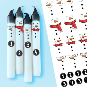 Könnte beinhalten: Vier weiße Kerzen im Schneemann-Design mit schwarzen Spitzen, jede mit einem anderen Gesicht, Schal oder Fliege verziert. Jede Kerze hat eine Nummer von 1 bis 4. Rechts befindet sich ein Bogen mit Schneemann-Aufklebern.