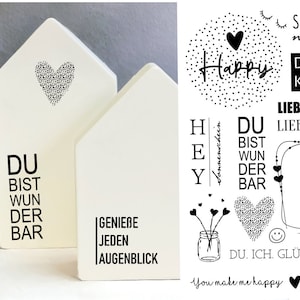 Puede incluir: Dos casas de madera blancas con texto negro. La primera casa dice "Du bist wunderbar" y la segunda casa dice "Genieße jeden Augenblick".