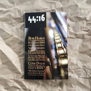 May include: A magazine cover with the title "44:16" and a photo of a bicycle chain. The cover features articles about Bob Haro, '70s skateboards, and Curb Dogs.
