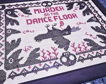 Puede incluir: Bordado de punto de cruz con hilo negro sobre tela blanca que representa una escena de cuervos y el texto "Murder on the Dance Floor". El bordado está enmarcado en negro y la esquina inferior derecha tiene el texto "Evil Twins" en blanco.