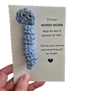 Può includere: Un verme di preoccupazione di uncinetto blu con occhietti e il testo "Sono il tuo VERME DI PREOCCUPAZIONE Tienimi vicino e stringimi forte. Dimmi le tue preoccupazioni e tutto andrà bene."