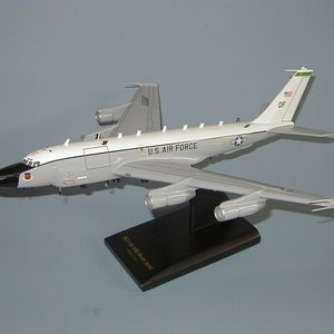 May include: A white and gray model airplane with black accents and the words "U.S. AIR FORCE" on the side. The model is on a black stand with the words "EC-121 Warning Star Aircraft" printed on it.