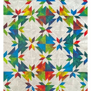 May include: A quilt with a geometric pattern of red, blue, green, and yellow triangles. The quilt is made of fabric with a tie-dye pattern.