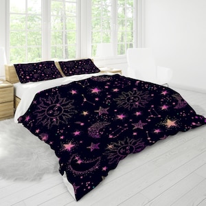 May include: A black duvet cover with a pink and gold celestial pattern featuring stars, moons, and suns. The pattern is repeated throughout the duvet cover.