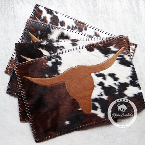 Puede incluir: Juego de seis manteles individuales de piel de vaca marrón, negro y blanco con un diseño de cabeza de toro de cuero marrón. Cada mantel individual tiene un borde cosido. Los manteles individuales son de Prime Cowhide Hides & Skins, Est. 1995.