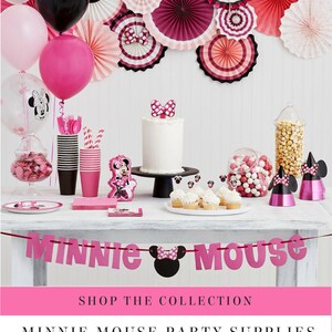 May include: A festive Minnie Mouse party scene with pink and black decorations. Includes balloons, paper fans, a cake, cupcakes, and candy. A banner spells out "Minnie Mouse".