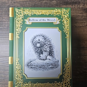 May include: Green and gold decorative book with the title "Bellow of the Woods". The cover features a black and white illustration of a bear. The book has a decorative gold border and spine.