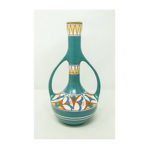 May include: A teal ceramic vase with two handles and a geometric pattern in yellow, orange, blue, and white.