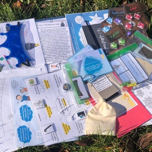 Puede incluir: Una colección de materiales educativos islámicos para niños, que incluyen páginas para colorear, tarjetas de actividades y una pequeña bolsa. Los materiales presentan texto e ilustraciones árabes.