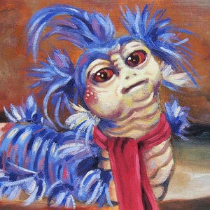 May include: A blue and purple fuzzy worm with a red scarf. The worm has a large head with a white face and red eyes. The worm is looking to the right.