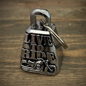 Può includere: Campana per moto in argento con un anello e le parole "Live to Ride" e una grafica di una moto.