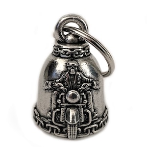 May include: Silver motorcycle bell keychain with a skull riding a motorcycle. The bell has a chain design around the top and bottom.