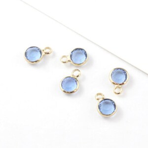 Puede incluir: Cinco abalorios dorados con cuentas redondas de cristal azul claro. Cada abalorio tiene un bucle para sujetarlo a joyas.