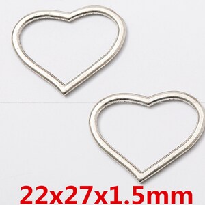 Puede incluir: Dos marcos de metal en forma de corazón plateados, cada uno mide 22 x 27 x 1,5 mm. Estos marcos son perfectos para manualidades y la elaboración de joyas.