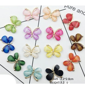 Puede incluir: Surtido de 15 adornos de resina en forma de mariposa de colores vivos con detalles dorados. Cada mariposa mide 2,2 por 2,8 cm.