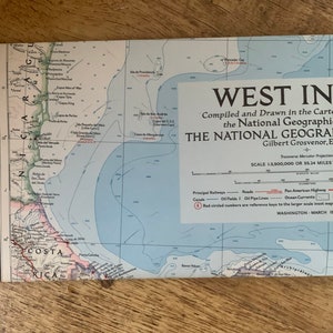 May include: A vintage map of the West Indies, compiled and drawn by the National Geographic Society in March 1954. The map features a detailed outline of the islands, including the Caribbean Sea, the Gulf of Mexico, and the Atlantic Ocean. The map also includes various geographical features, such as rivers, mountains, and cities.