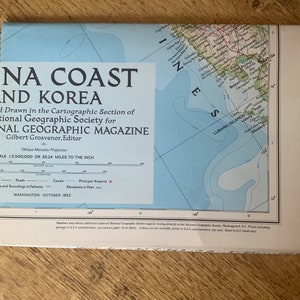 May include: A vintage map of the coast of China and Korea, published by the National Geographic Magazine in October 1953. The map is printed on a light blue background with brown lines and text. The map shows the coastline, islands, and major cities. The map is titled "NA Coast and Korea" and includes a scale of 1:3,500,000 or 55.24 miles to the inch.