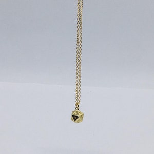 May include: A gold chain necklace with a gold 20-sided die pendant.