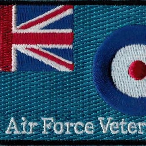 May include: An embroidered patch in blue and white, featuring the Union Jack flag and a roundel, a blue circle with a white centre and a red dot. The text "Royal Air Force Veteran" is embroidered in white below the patch.