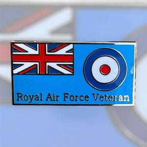 May include: A blue and white enamel pin featuring the Union Jack flag and the Royal Air Force roundel. The pin reads "Royal Air Force Veteran".